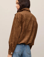 Z SUPPLY Corin Bubble Hem Jacket in Saddle Suede — back view on model, brown faux suede with cropped bubble hem and button cuffs, paired with blue jeans.